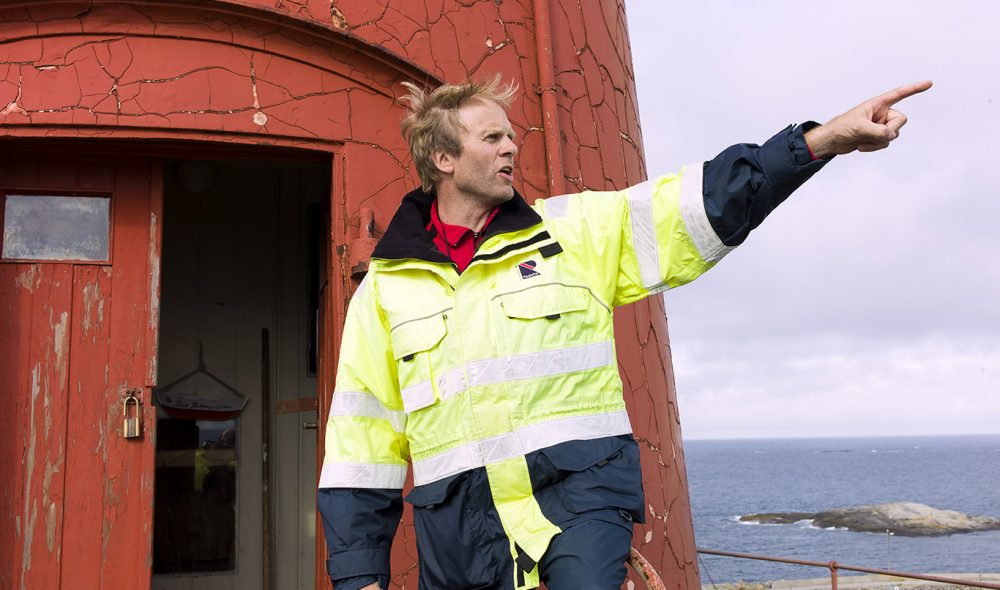 MANGE HISTORIER: RIB-skipper Kolbjørn Ove Stølen forteller historier om livet på Ona. Legg merke til den værbitte ytterveggen på selve fyret.