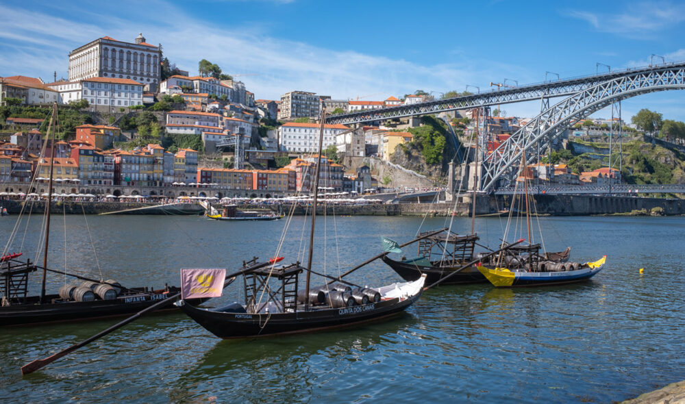 PÅ UTSTILLING: De fleste som besøker Porto ender på et eller annet tidspunkt på Vila Nova de Gaia-siden. I forkant de typiske rabelo-båtene, som i sin tid fraktet vinen langs elven til portsvinshusene ved elvebredden. I bakgrunnen Maria Pia-bruen, konstruert av Gustave Eiffel og bygget fra 1876 til 1877 på oppdrag av kongen av Portugal og oppkalt etter dronningen med samme navn.