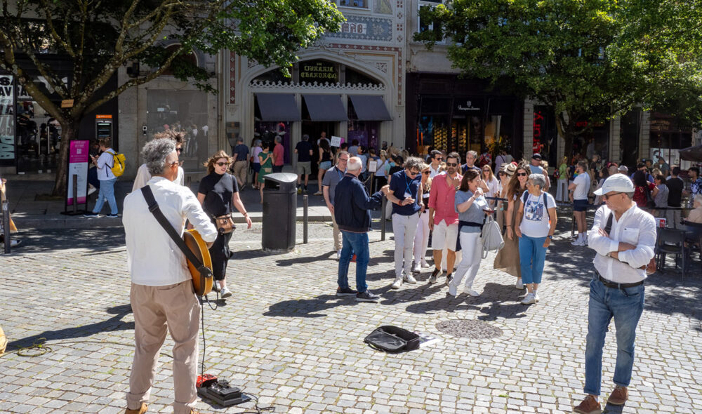 BERØMT BOKHANDEL: Utenfor bokhandelen Livraria Lello & Irmão, som særlig forfatteren J. K. Rowling gjorde kjent, er køene lange. Det benytter mange gateartister seg av.